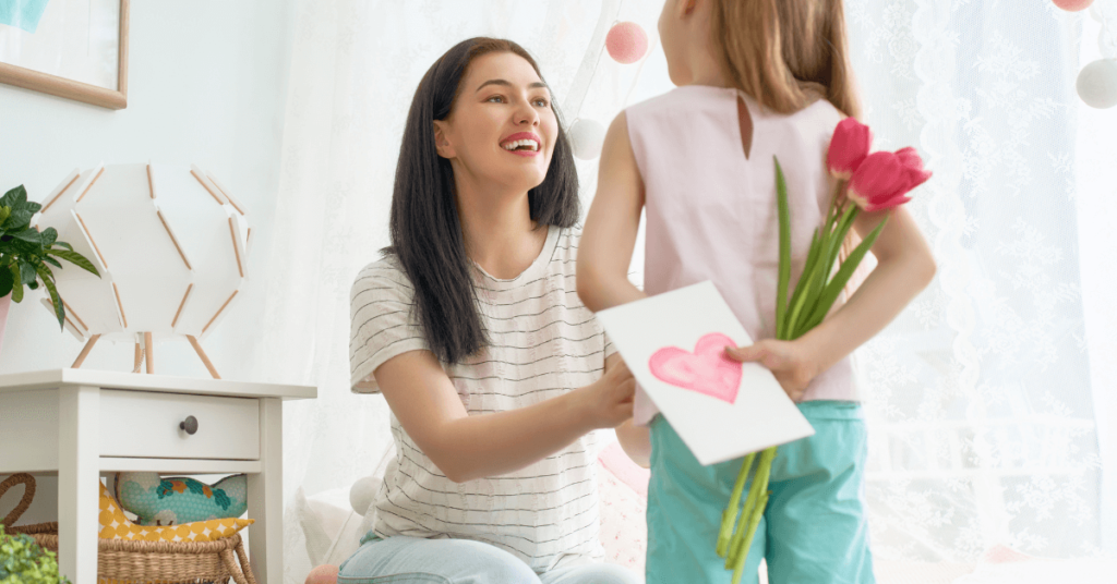 girl bringing flowers and birthday card to mom