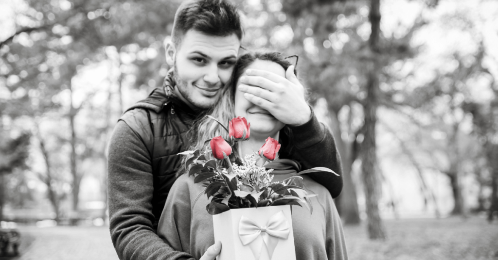 boy giving girlfriend present with roses